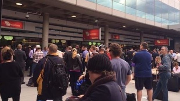 Passenger wait outside the terminal after being evacuated.