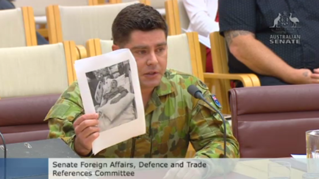 Former SAS trooper Evan Donaldson shows a Senate inquiry a photograph of his brother Andrew in a coma.