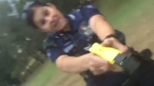 A Queensland police officer with a Taser appears in a video posted to Facebook.