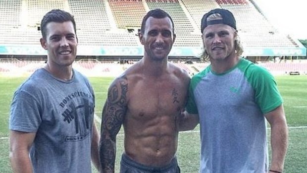 Quade Cooper works out at Ballymore with Brisbane Lions left footer Daniel Rich and the AFL side's strength and conditioning coach, Matt Hass.