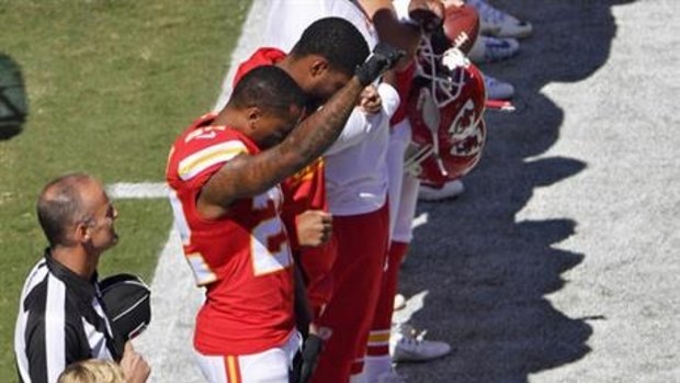 Protest: Kansas City Chief's cornerback Marcus Peters raises his fist as the US national anthem is played.