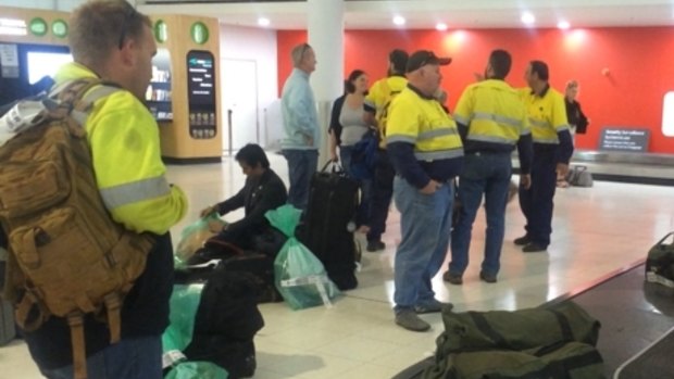 FMG workers arrive back at Perth Airport after being told to pack up their belongings at Cloudbreak minesite.

