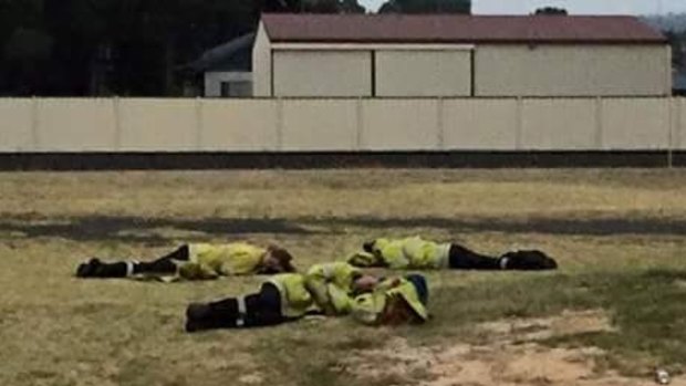 Exhausted firefighters kip on the lawn outside Harvey fire station. 