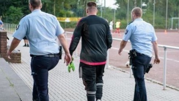German goalkeeper Marco Kwiotek is led away by police.