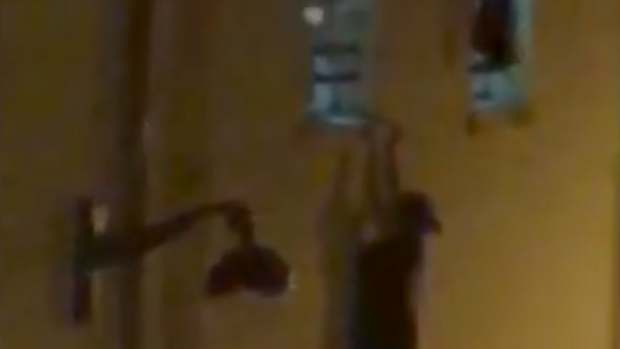 The pregnant woman dangles from the Bataclan concert hall window sill.