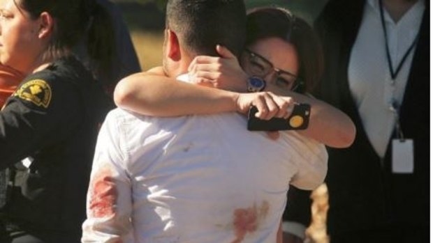 Survivors console each other at scene of the mass shooting in San Bernadino.