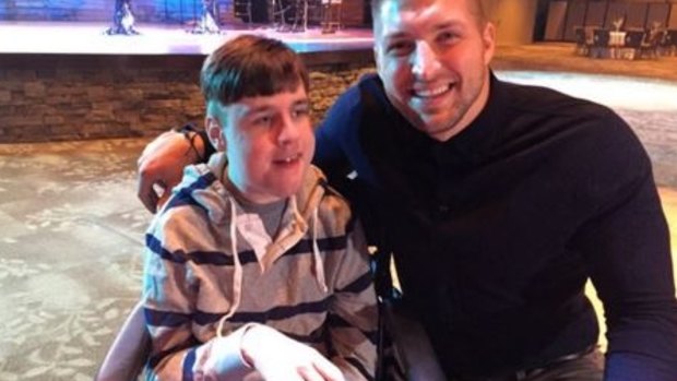 Spreading the love: Tim Tebow with a young fan.