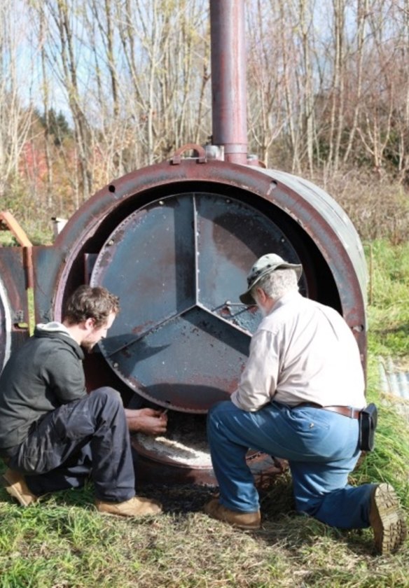 Braidwood forester Peter Marshall, right, with his portable biochar retort.