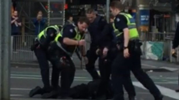 Police subdue the suspect at Flinders Street on Grand Final Day