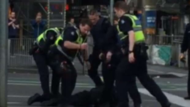 Police subdue the suspect at Flinders Street on Grand Final Day