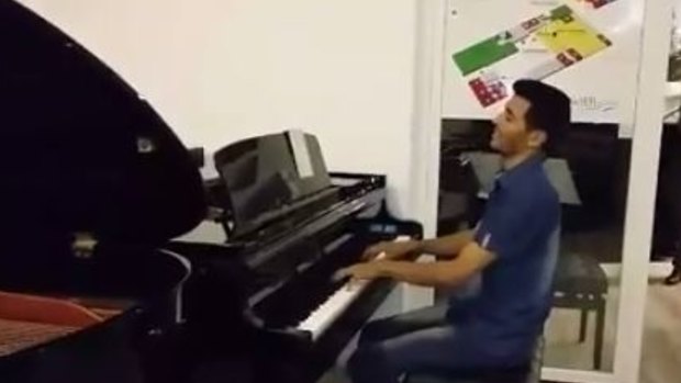 Ayham al-Ahmed playing the piano in a video he posted on Monday.
