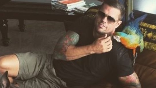 Darren Mohr poses in his Vaucluse apartment with his macaw Paris.