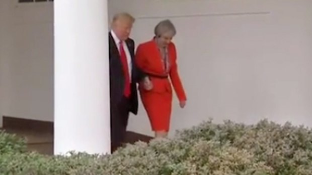 Donald Trump and Theresa May hold hands after their meeting.