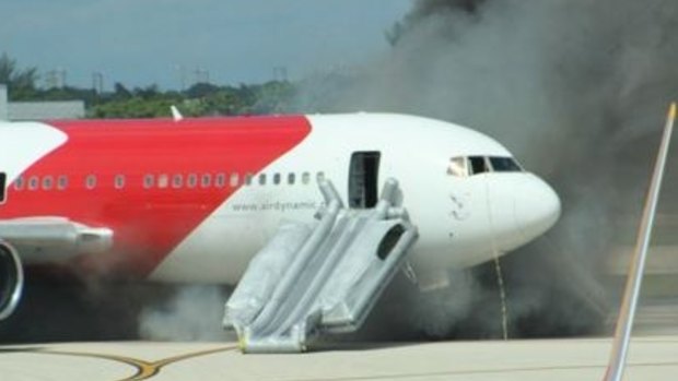 A passenger slide is deployed on the Dynamic International Airways Boeing 767 which caught fire on the airport runway at Fort Lauderdale, Florida.