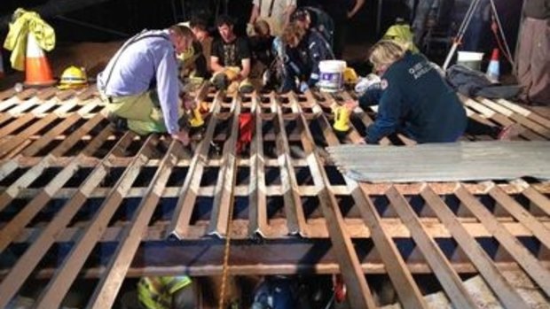Emergency services personnel work to free a man trapped in a silo.