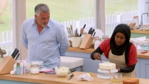 Judge Paul Hollywood looks as Nadiya Hussain works on her cake on <i>The Great British Bake Off</i>. 
