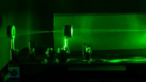 A laser shows the paths that light rays travel through the system, showing regions that can be used for cloaking an object.