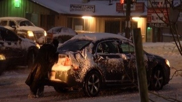 Homeless man Shelby Hudgens helps push stricken cars during a snow storm in Colorado Springs.