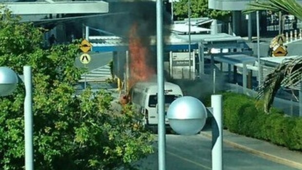 A maxi taxi on fire at Brisbane Airport.