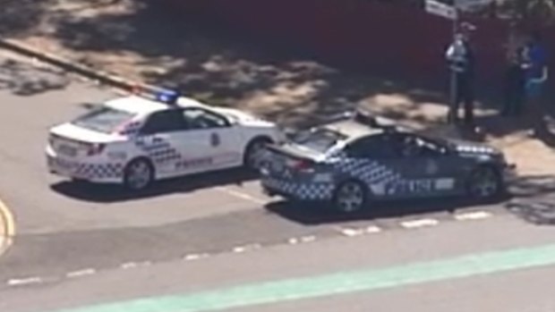 Police surround a man during a seige at an Inala home.