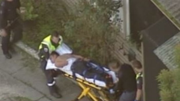 The alleged attacker wheeled out of the Doveton house on a stretcher.