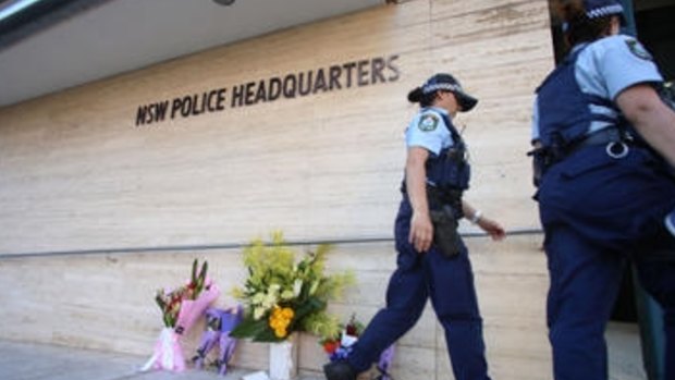 Police officers leave flowers outside police headquarters in Parramatta.
