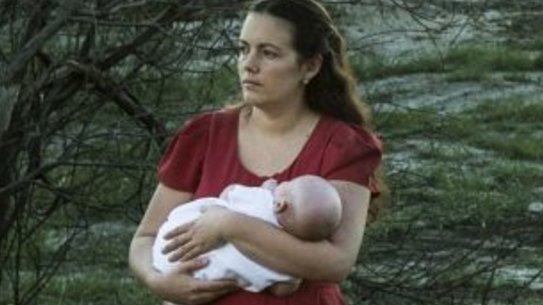 Samantha Kelly holds her baby William beside one of the drains running from the Williamtown RAAF base near Newcastle.