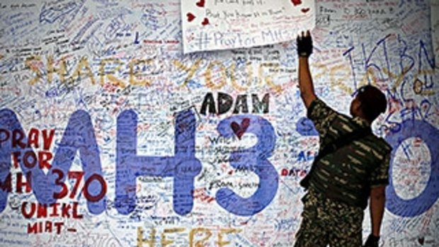 A soldier checks a memorial for the victims of Malaysia Airlines flight MH370.