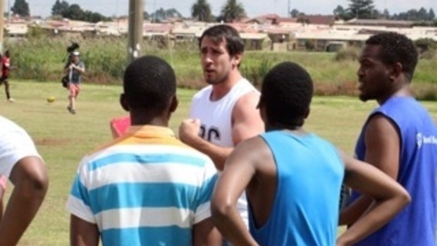 Reds prop Ben Daley with Soweto rugby club players.
