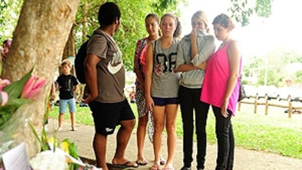 Mourners gather outside house where eight children were killed in Cairns.