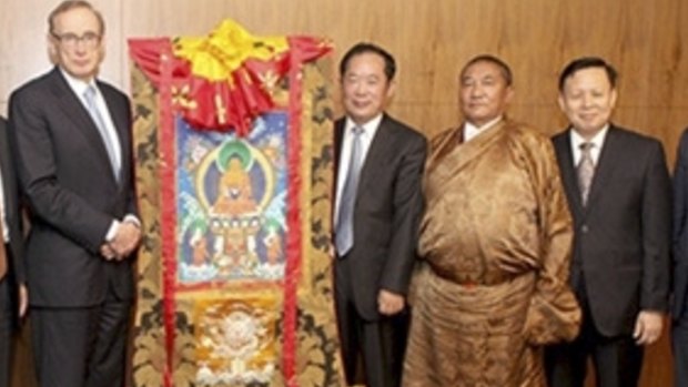 Bob Carr with Chinese official Zhu Weiqun (also standing next to the scroll) and "living buddha" Tudeng Kezhu (wearing a robe).