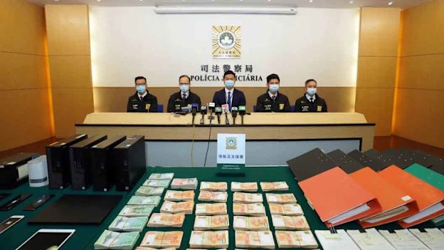 Computers, mobile phones and cash on display after the Chau arrest.