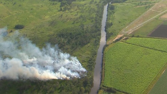 Smoke rises from the site of the crashed light plane.