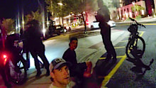 Dylan Moore (bottom left) and Connor Macdonald sit on the curb after their arrest in Scottsdale.
