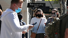 People walk through Brisbane CBD wearing masks.