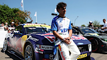 F1 driver Arvid Lindblad poses in front of the Ford Mustang Supercar ahead of his run at the Goodwood Festival of Speed.