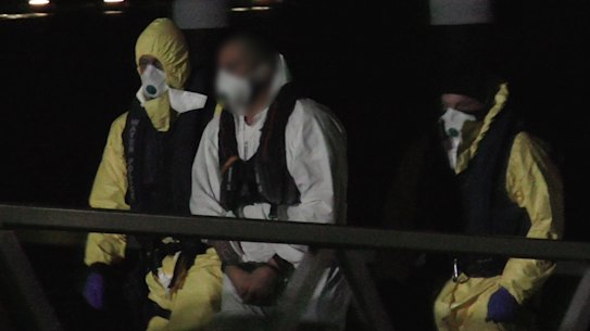 The men under police guard after their arrest.