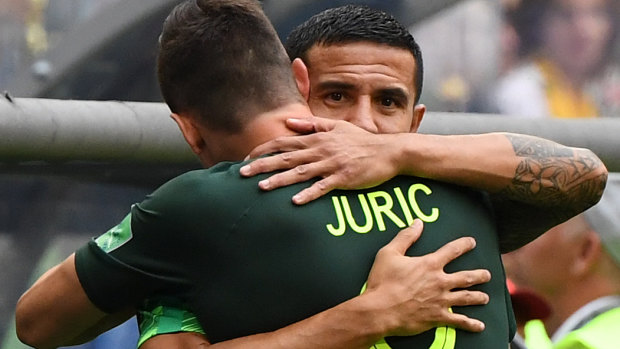 Cahill hugs Tom Juric as his teammate enters the game against Denmark.
