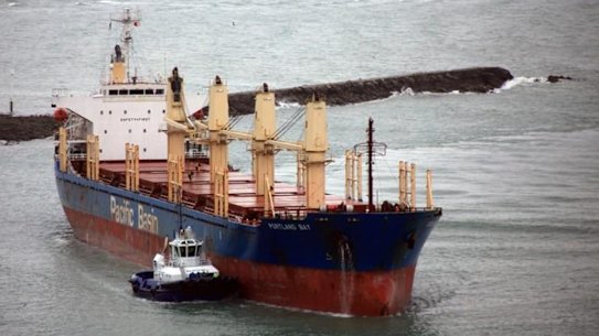 A tugboat aids the Portland Bay, a bulk carrier in danger of running aground off Wattamolla in July.