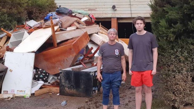Joe Booker and son Benjamin outside their Lismore home that was destroyed in the floods. 