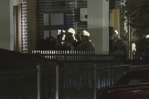 Police storm the Fairfield West address on Sunday.
