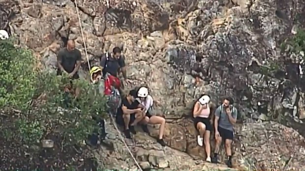 Some of the 16 climbers stuck on a mountain north-west of Brisbane wait to be rescued earlier on Saturday.