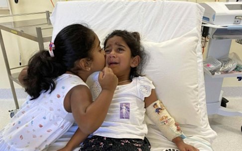 Tharnicaa and her sister Kopika in hospital on Christmas Island on June 6.