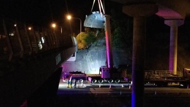 A crane was used to free the truck and its load from the M1 Pacific Motorway off-ramp.