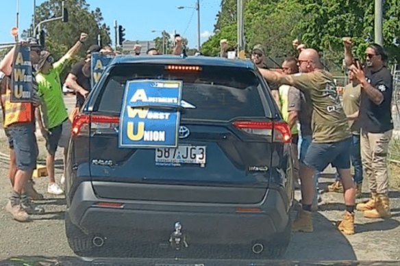 CFMEU members surround an AWU organiser’s car at the Centenary Bridge upgrade site.