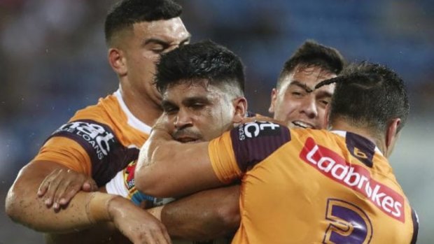Gold Coast recruit Tyrone Peachey is tackled by the Broncos.