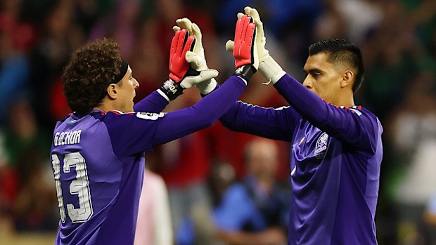 Guillermo Ochoa of Mexico high fives with Raul Rangel as he comes on as substitute.