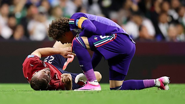 Guillermo Ochoa (R) speaks with to Tomas Soucek (L) as he awaits medical attention.