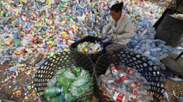 A worker separates plastic bottles at a recycling depot in Beijing.