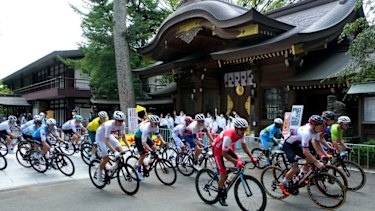 Road race cyclists in action at Musashiononomori Park on the first day of the Tokyo 2020 Olympic Games in Japan.